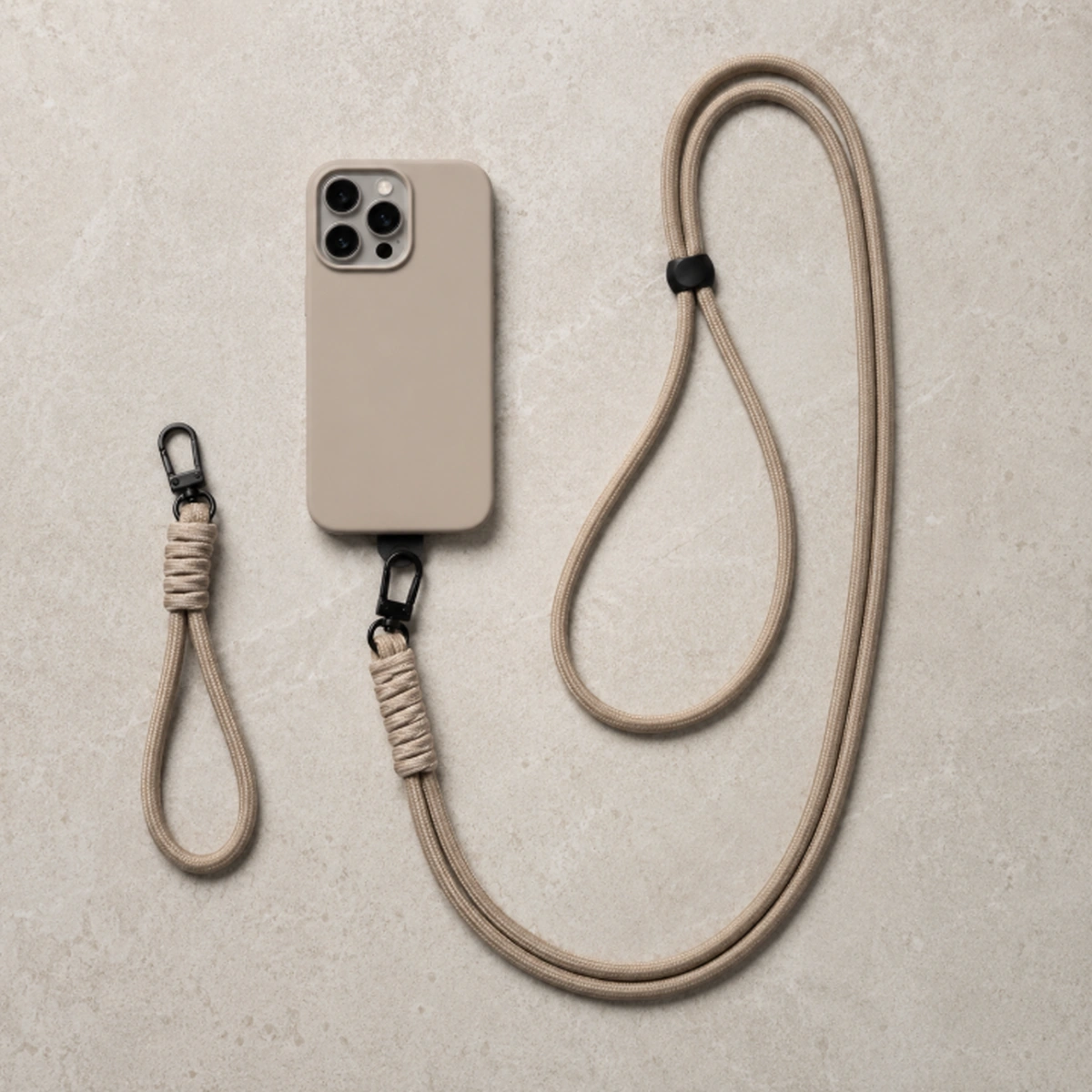 polskoord en crossbody telefoonkoord naast telefoonhoesje op lichte betonnen achtergrond