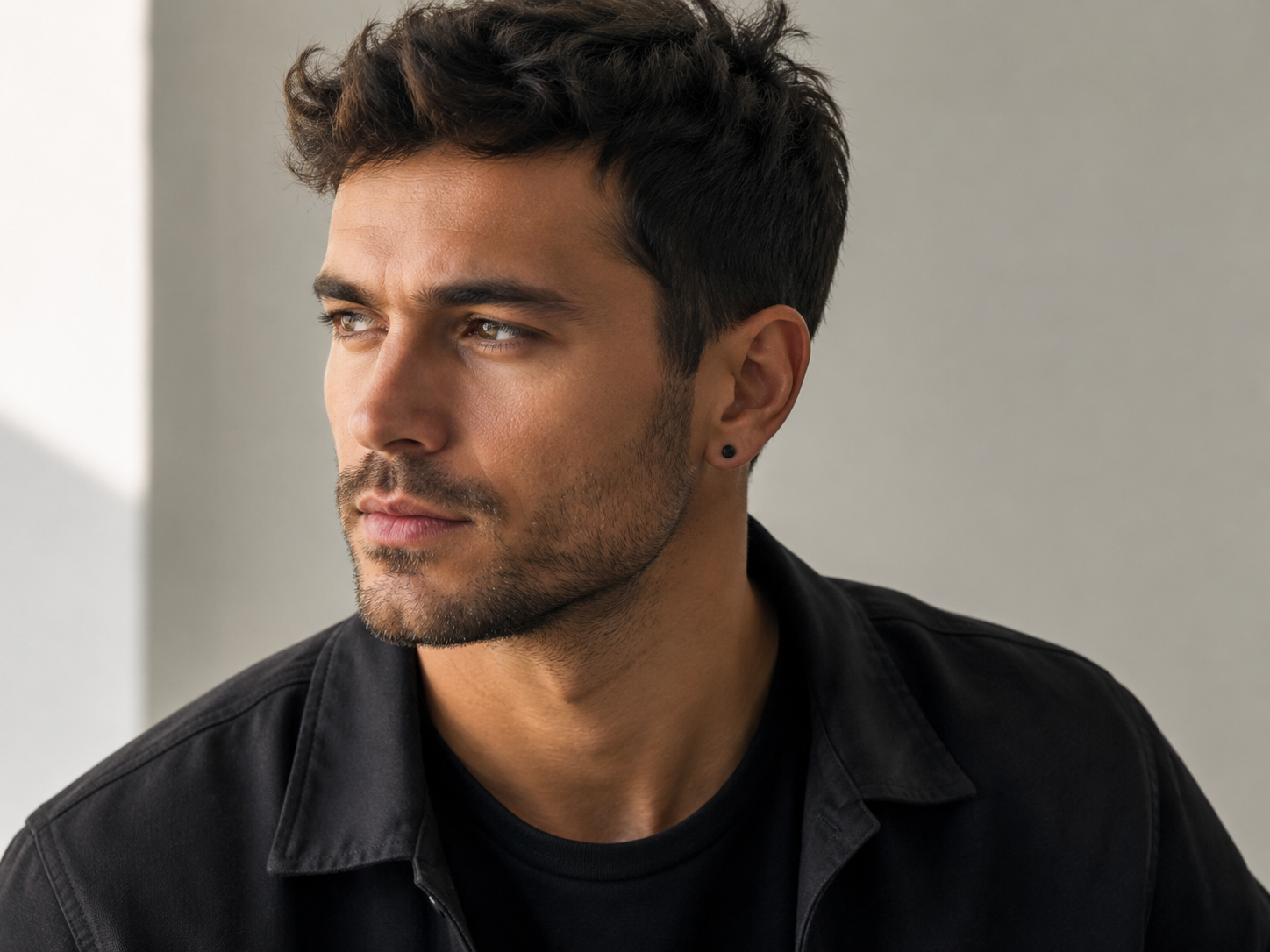 Man met subtiele zwarte heren oorbel en moderne casual outfit