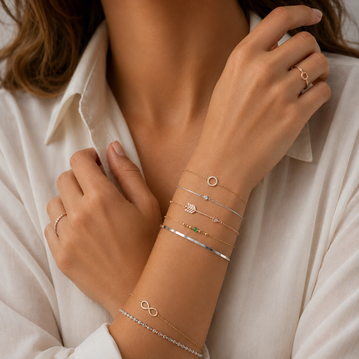 vrouw draagt fijne minimalistische armbanden in goudkleurige en zilverkleurige tinten