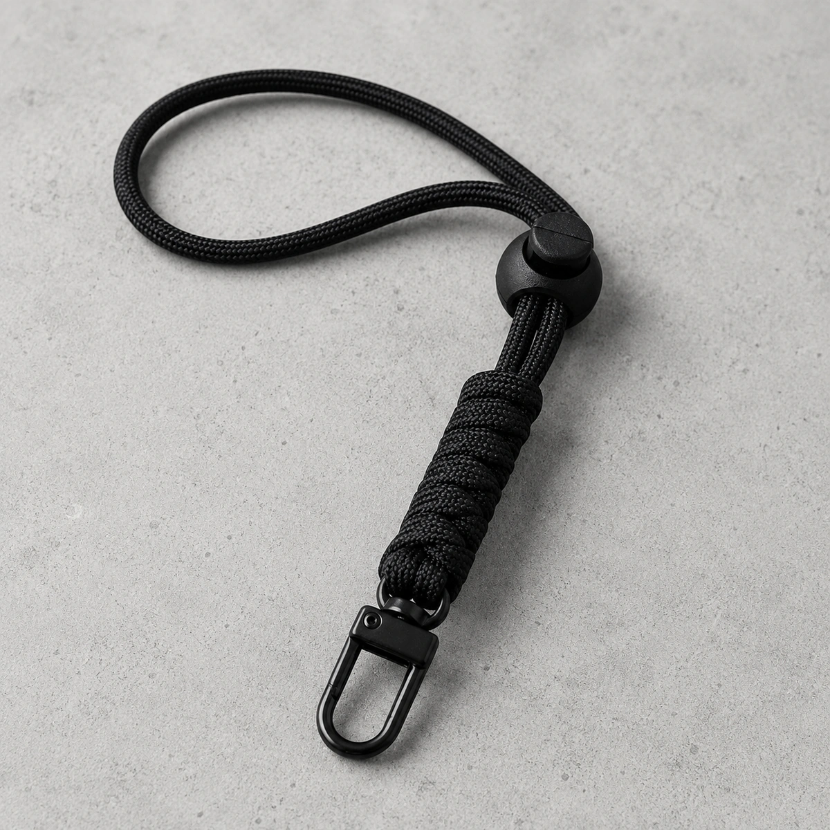 paracord telefoonkoord met karabijnsluiting op lichte betonnen achtergrond