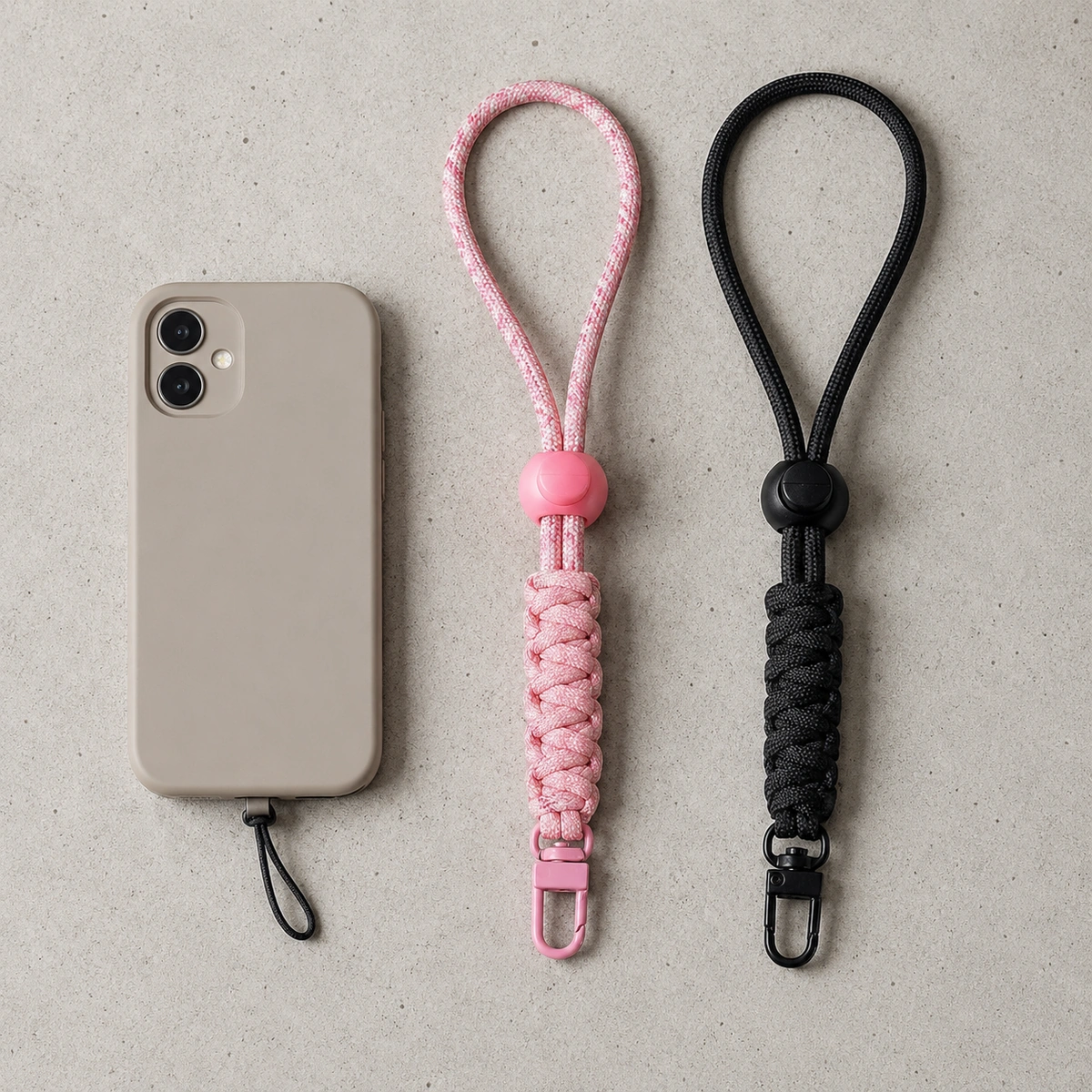 macramé telefoonkoord en paracord telefoonkoord naast elkaar op lichte betonnen achtergrond
