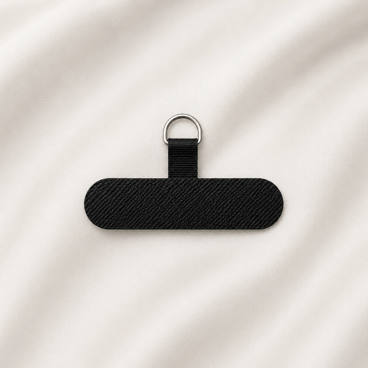 zwarte telefoonpatch met metalen ring op een rustige nylon achtergrond